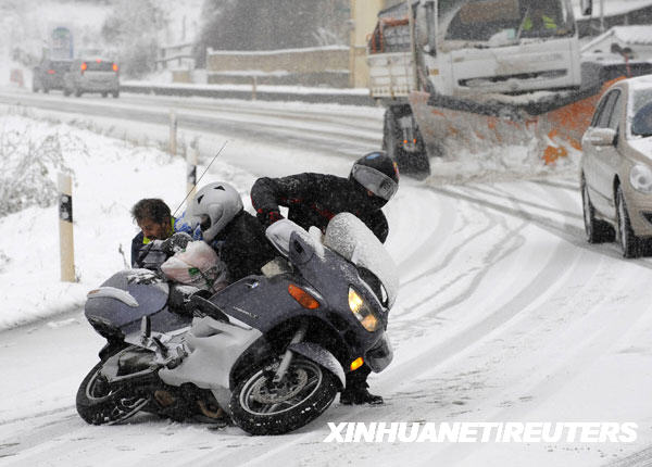 1月8日,在西班牙坎波马内斯,一名骑摩托车的男子在雪地中滑倒.