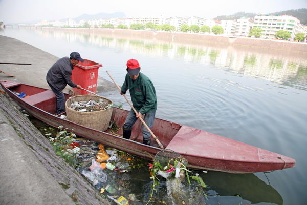 张光平和同伴在芹江河面上打捞清理垃圾