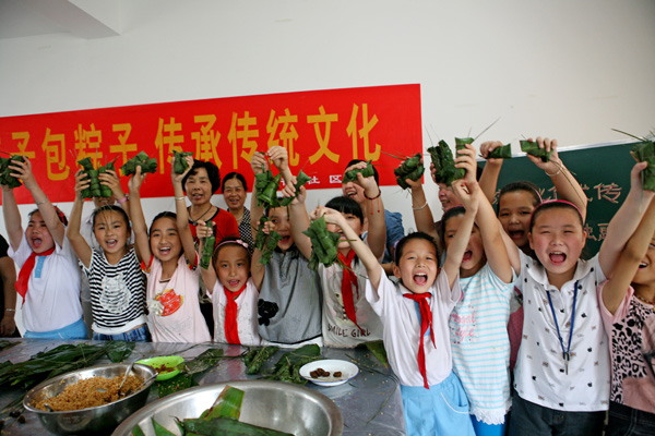 开化华埠横街社区奶奶阿姨手把手教留守儿童包粽子传承传统文化